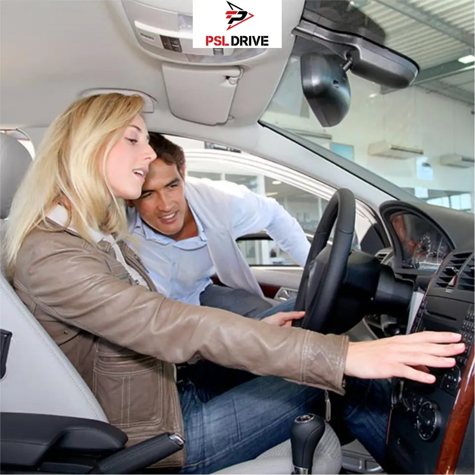 A customer sits in the driver's seat of a car at a dealership while a sales representative explains the dashboard controls and interior features. The PSL Drive logo is displayed at the top of the image.
